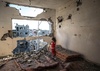 Menina palestina fica em sua casa destruída em Gaza