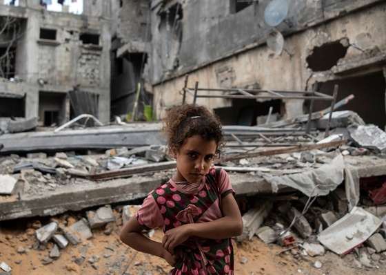 A palestina Rahaf Nuseir, 10 anos, observa enquanto ela fica em frente às casas destruídas de sua família