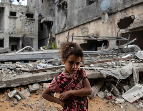La palestina Rahaf Nuseir, de 10 años, observa mientras se encuentra frente a las casas destruidas de su familia.